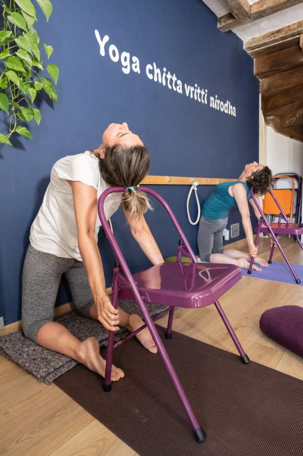 Cours de yoga position chameau avec chaise
